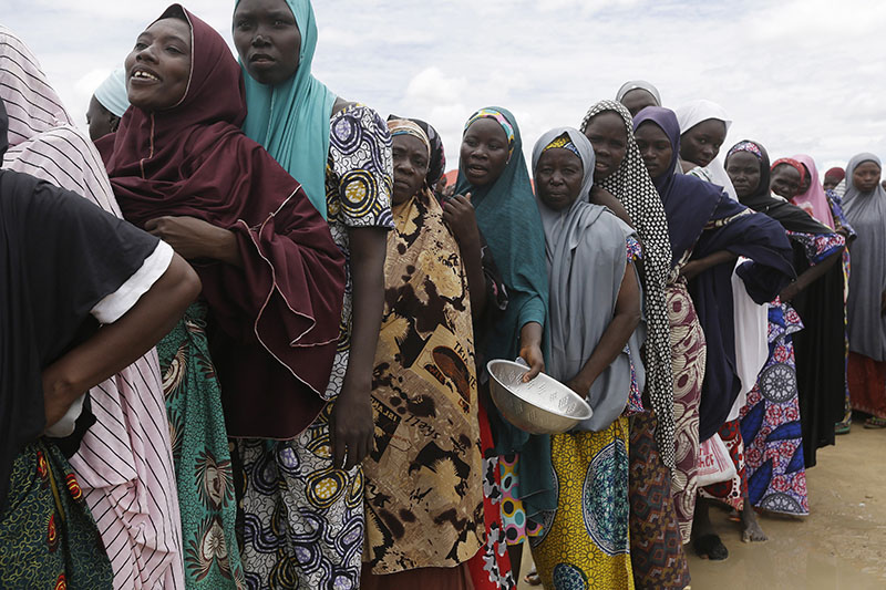 FILE- Women displaced by Islamist extremists wait for food to be handed out to them at the Bakassi camp in Maiduguri, Nigeria, on Saturday, August 27, 2016. Photo: AP