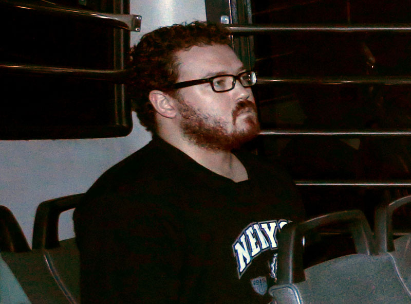 File - Rurik George Caton Jutting, a British banker charged with two counts of murder after police found the bodies of two women in his apartment, sitting in the back row of a prison bus as he arrives at the Eastern Law Courts in Hong Kong, on November 24, 2014. Photo: Reuters