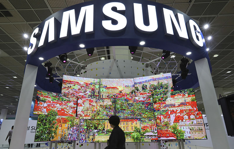 FILE - A visitor walks by Samsung Electronics TV screens at Korea Electronics Show or KES in Seoul, South Korea, on October 26, 2016. Photo: AP