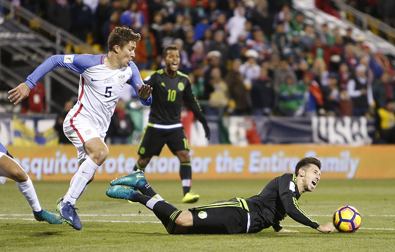 Mexico's Hector Herrera (right) falls to the ground as United States' Matt Besler looks for the ball during the second half of a World Cup qualifying soccer match, on Friday, November 11, 2016, in Columbus, Ohio. Photo: AP