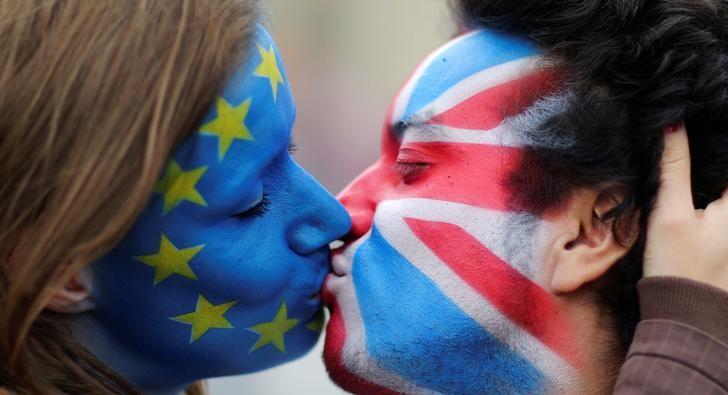 Two activists with the EU flag and Union Jack painted on their faces kiss each other in front of Brandenburg Gate to protest against the British exit from the European Union, in Berlin, Germany, June 19, 2016. REUTERS/Hannibal Hanschke/File Photo