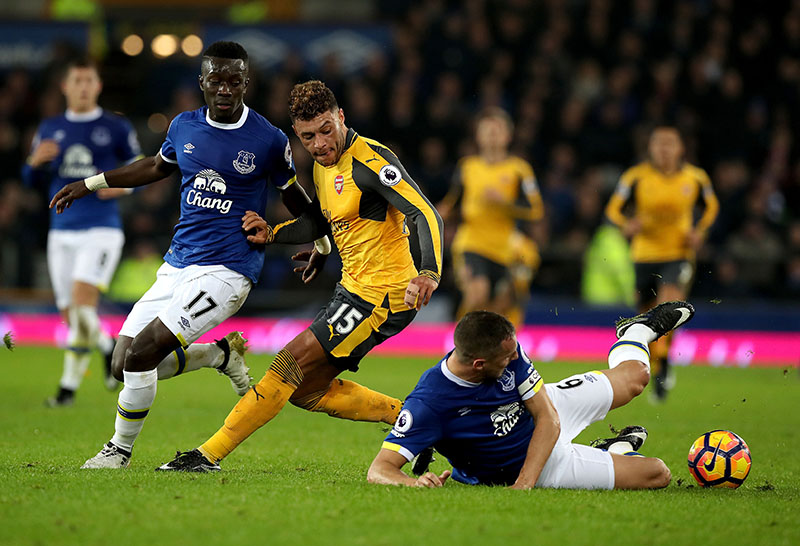 Arsenal's Alex Oxlade-Chamberlain, centre, contends with Everton players Idrissa Gueye (left) and Phil Jagielka (right) during their English Premier League football match at Goodison Park in Liverpool, England, on Tuesday, December 13, 2016. Photo: Peter Byrne / PA via AP