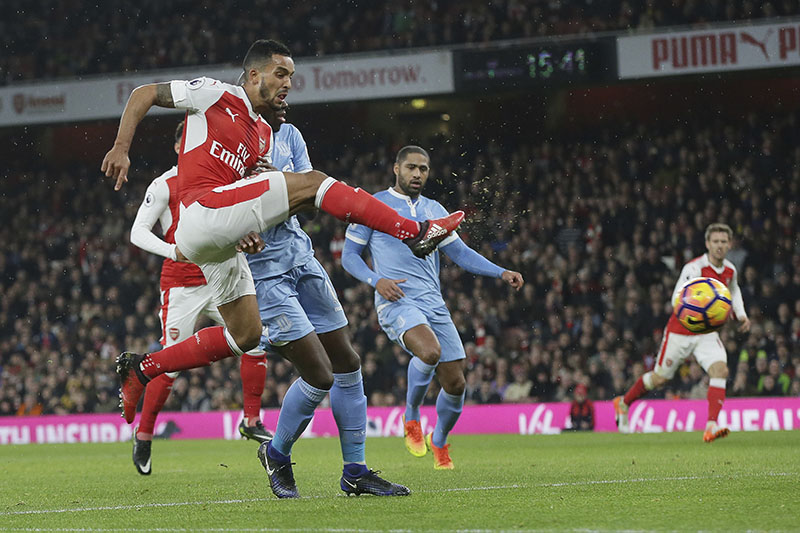 Arsenal's Theo Walcott (left) beats Stoke City's Bruno Martins Indi to score a goal during the English Premier League soccer match between Arsenal and Stoke City at the Emirates stadium in London, on Saturday, December 10, 2016. Photo: AP
