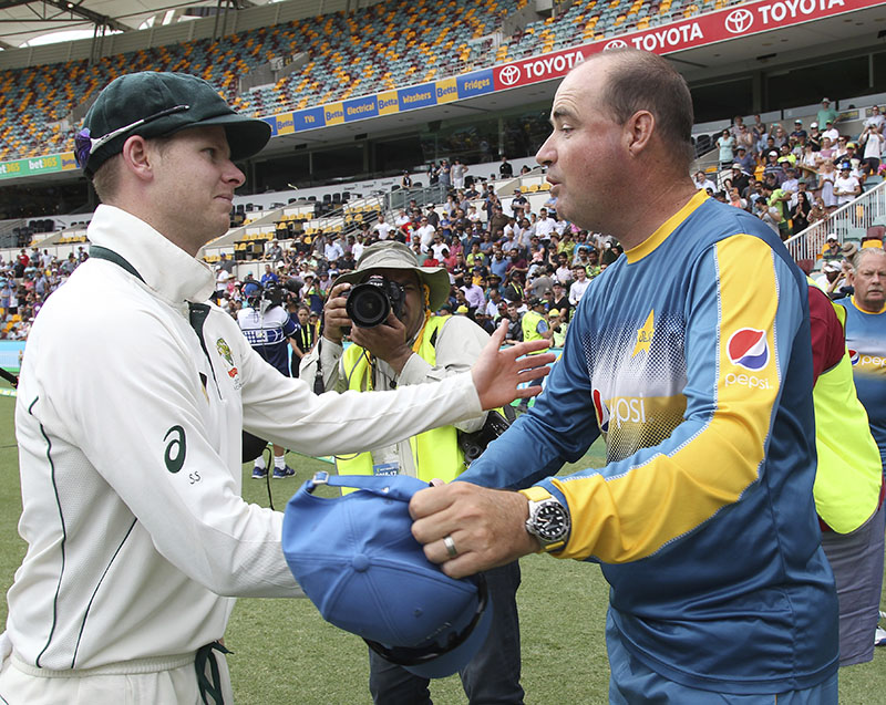 Australian captain Steve Smith shakes hands with Pakistan's coach Mickey Arthur, right, after Australia's victory on the final day of the first cricket test between Australia and Pakistan in Brisbane, Australia, on Monday, December 19, 2016. Photo: AP