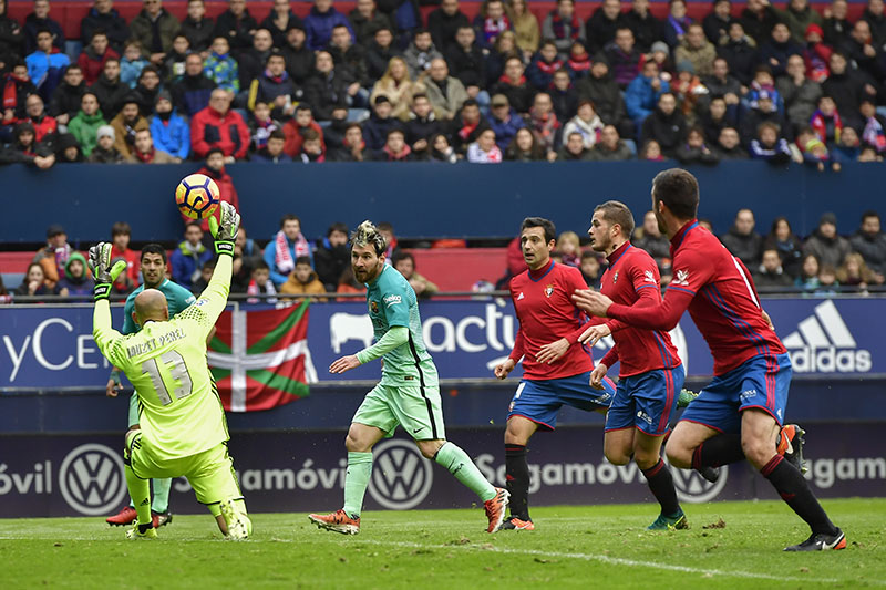 FC Barcelona's Lionel Messi, second left, shoots but misses scoring a goal in front of Osasuna's goalkeeper Nauzet Perez, during the Spanish La Liga soccer match between FC Barcelona and Osasuna, at El Sadar stadium, in Pamplona, northern Spain, on Saturday, December 10, 2016. Photo: AP