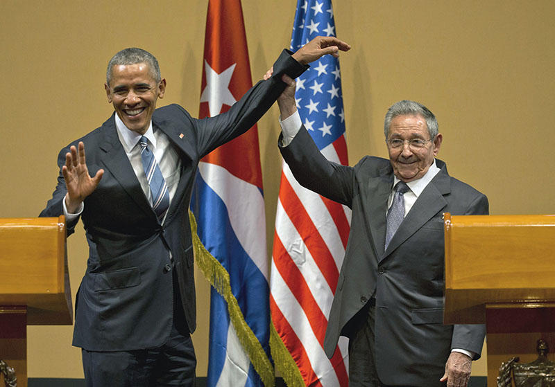 FILE - Cuban President Raul Castro (right) lifts up the arm of US President Barack Obama, at the conclusion of their joint news conference at the Palace of the Revolution, in Havana, Cuba, on March 21, 2016. Photo: AP