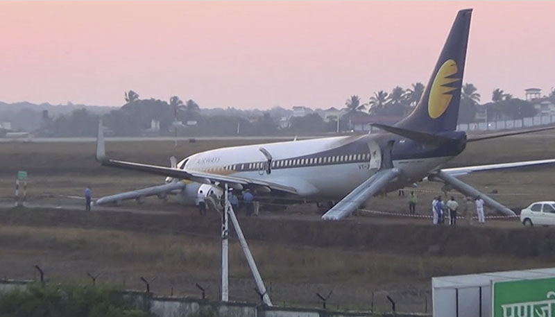 Officials and workers stand by a Jet Airways plane which skidded off runway at Goa International Airport in Goa, western India, on Tuesday, December 27, 2016. Photo: KK Productions/APTN via AP