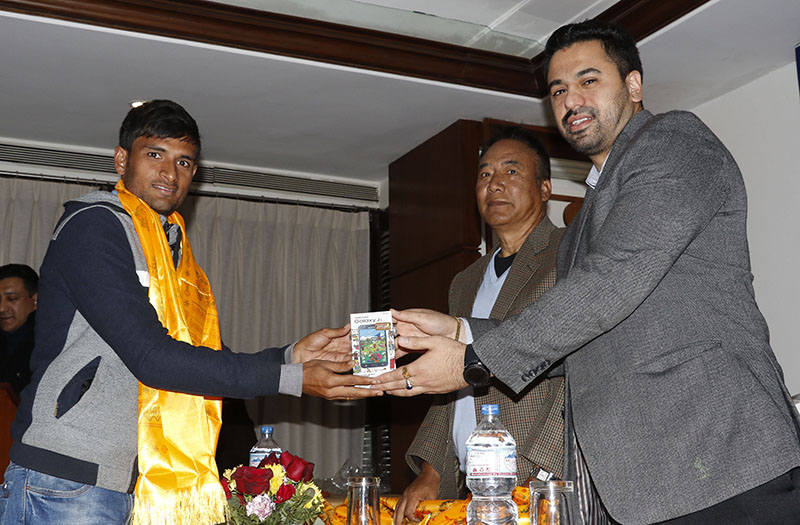 IMS Group President and CEO Dikesh Malhotra handing over a Samsung mobile set to national football team defender Rabin Shrestha as ANFA Honorary President Tashi Ghale looks on during a felicitation programme in Kathmandu on Monday, December 19, 2016. Photo: THT