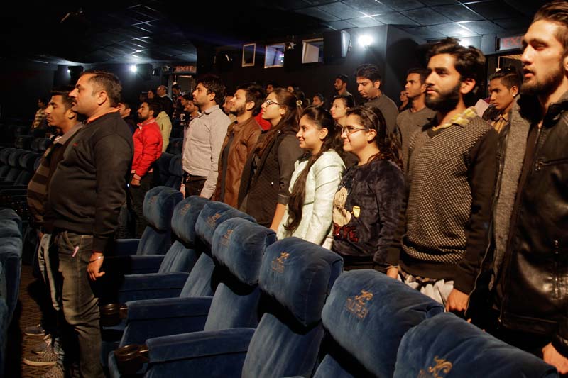 Indian movie goers stand up as national anthem is played at a movie hall before the screening of a movie in Jammu, India, on Tuesday, December 13, 2016. Photo: AP