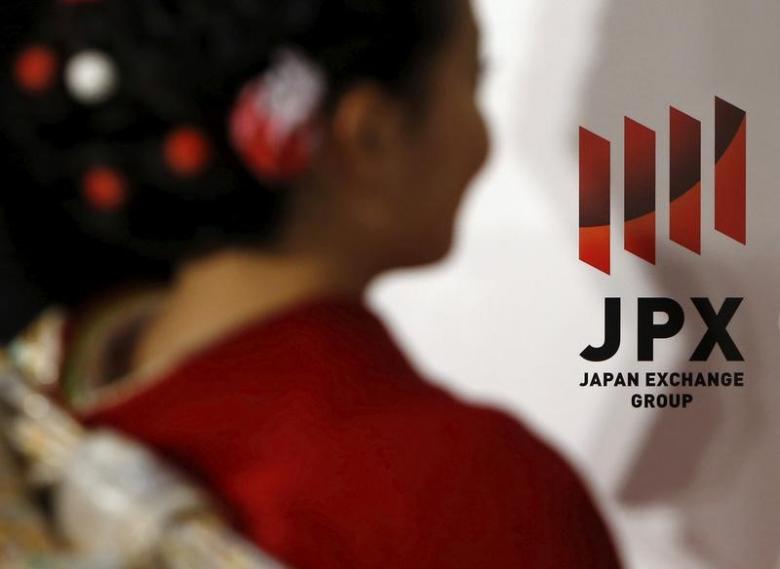 A logo of Japan Exchange Group Inc. is seen next to a woman, dressed in ceremonial kimono at the Tokyo Stock Exchange (TSE),  in Tokyo, Japan, January 4, 2016.   REUTERS/Yuya Shino/File Photo