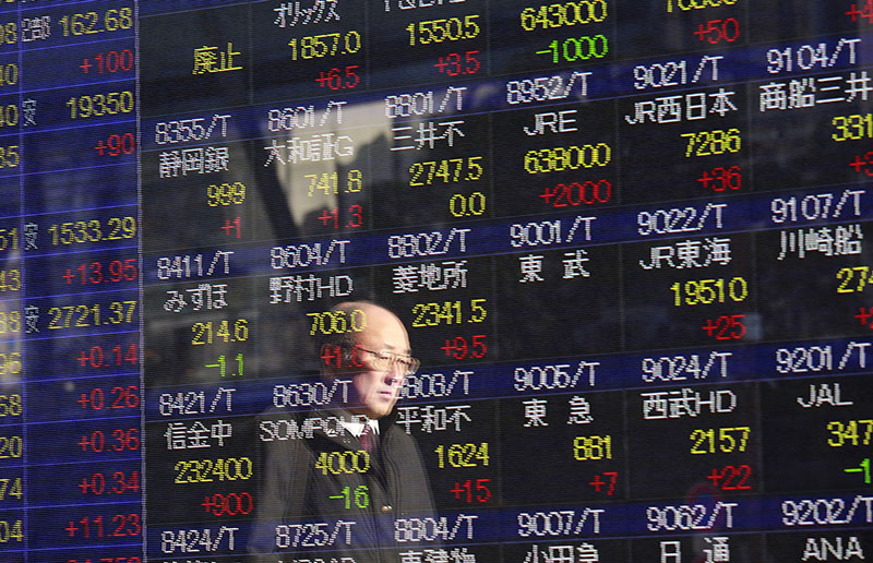 A man is reflected on an electronic stock indicator of a securities firm in Tokyo, on Wednesday, December 28, 2016.  Photo: AP