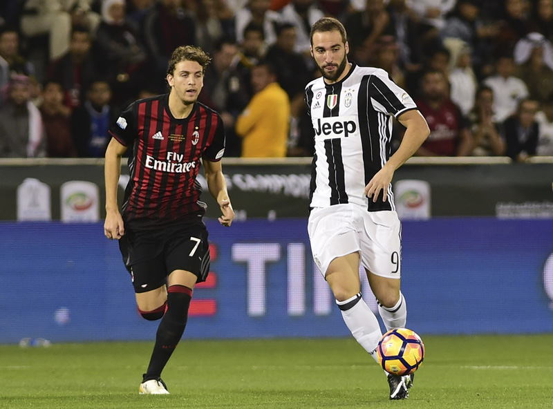 Juventus's Gonzalo Higuain, right, gets the ball past AC Milan's Manuel Locatelli during the Italian Super Cup soccer match between Juventus and AC Milan, at the Al Sadd Sports Club in Doha, Qatar, Friday, Dec. 23, 2016. Photo: AP