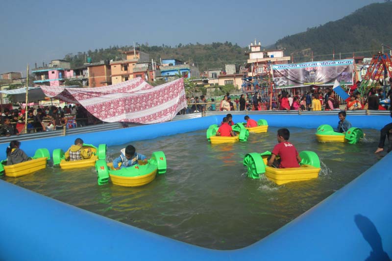 Children play at an artificial pond during the Bhimad Festival in Tanahun district, on Sunday, December 4, 2016. Photo: RSS