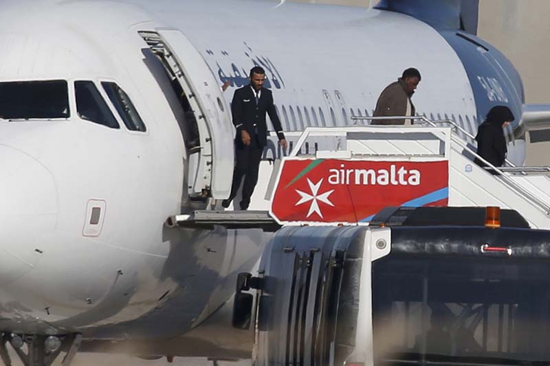 People disembark from a hijacked Libyan Afriqiyah Airways Airbus A320 on the runway at Malta Airport, on Friday, December 23, 2016. Photo: Reuters