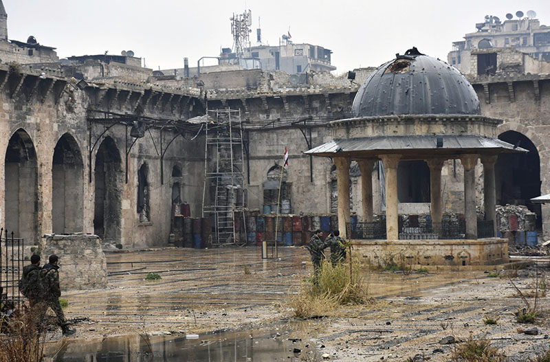 This photo released by the Syrian official news agency SANA, shows Syrian troops and pro-government gunmen marching walk inside the destroyed Grand Umayyad mosque in the old city of Aleppo, Syria on Tuesday, December 13, 2016. Photo: AP