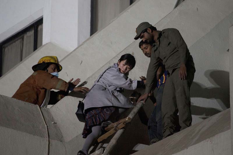 Pakistani volunteers help a foreigner to escape following a fire at a hotel in Karachi, Pakistan, on Monday, December 5, 2016. Photo: AP