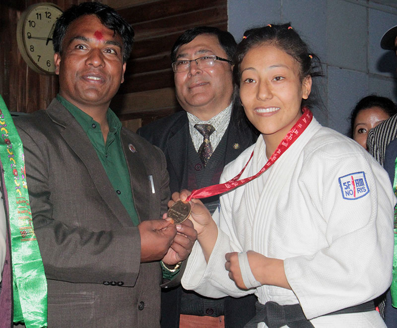 Olympian judoka Phupu Lhamu Khatri of TAC shows the gold medal with Youth and Sports Minister Daljit Sripaili in Jhapa, on Sunday, December 25, 2016. Photo: THT