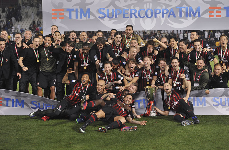 AC Milan team celebrate with the trophy after winning the Italian Super Cup soccer match between Juventus and AC Milan, at the Al Sadd Sports Club in Doha, Qatar, on Friday, December 23, 2016. AC Milan won 5-4 following a shootout. Photo: AP