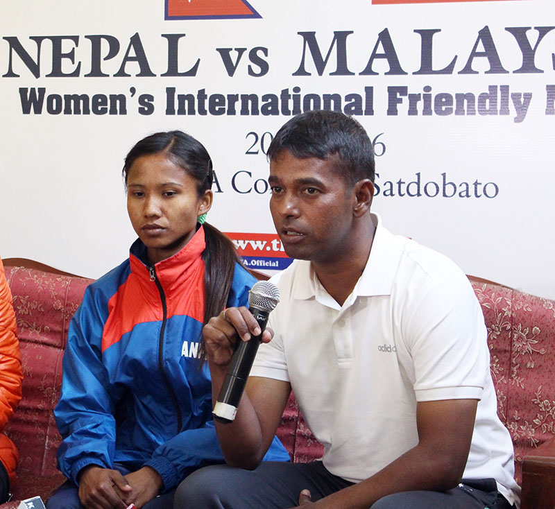 Nepal national womenu2019s football team coach Kumar Thapa speaks as skipper Renuka Nagarkote looks on during a press meet in Lalitpur on Friday, December 16, 2016. Photo:
