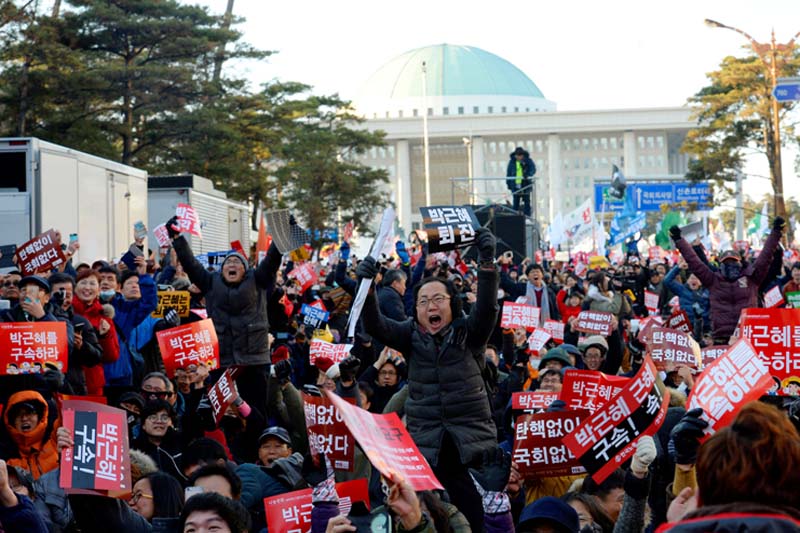 People react after impeachment vote on South Korean President Park Geun-hye was passed, in front of the National Assembly in Seoul, South Korea, on Friday, December 9, 2016. Photo: Reuters