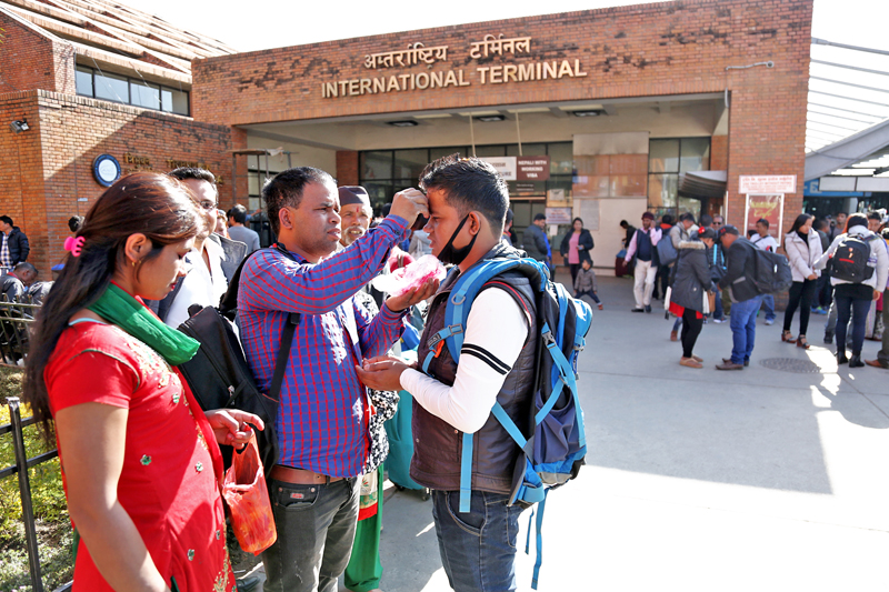 Relatives offer tika to their kin traveling abroad for employment, at the Tribhuvan International Airport in Kathmandu, on Wednesday, December 7, 2016. Photo: RSS