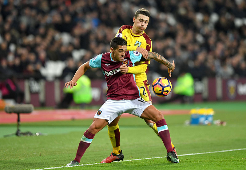 West Ham United's Manuel Lanzini, front, and Burnley's Matthew Lowton battle for the ball during their English Premier League soccer match at the London Stadium in London, on Wednesday, December 14, 2016. Photo: Dominic Lipinski/PA via AP