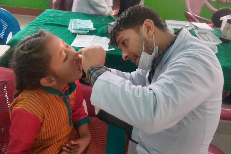 A dentist examines teeth of a girl at a health camp organised in Nayapati of Kathmandu, on Saturday, December 3, 2016. Photo: Guna Raj Pyakurel