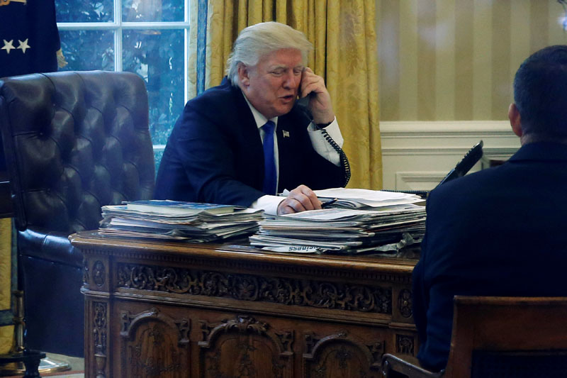 US President Donald Trump speaks by phone with Germany's Chancellor Angela Merkel in the Oval Office at the White House in Washington, US, on January 28, 2017. Photo: Reuters