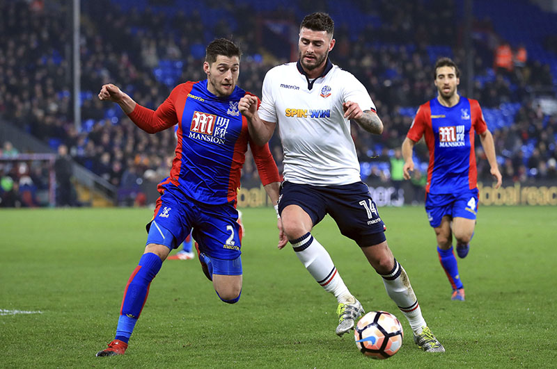 Crystal Palace's Joel Ward (left) and Bolton Wanderers' Gary Madine battle for the ball during the English FA Cup, third round replay match at Selhurst Park, London, on Tuesday January 17, 2017. Photo: Tim Goode/PA via AP