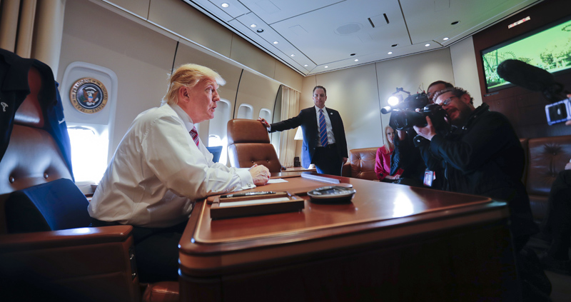 President Donald Trump sits at his desk on Air Force One upon his arrival at Andrews Air Force Base, Md., Thursday, Jan. 26, 2017. Photo: AP