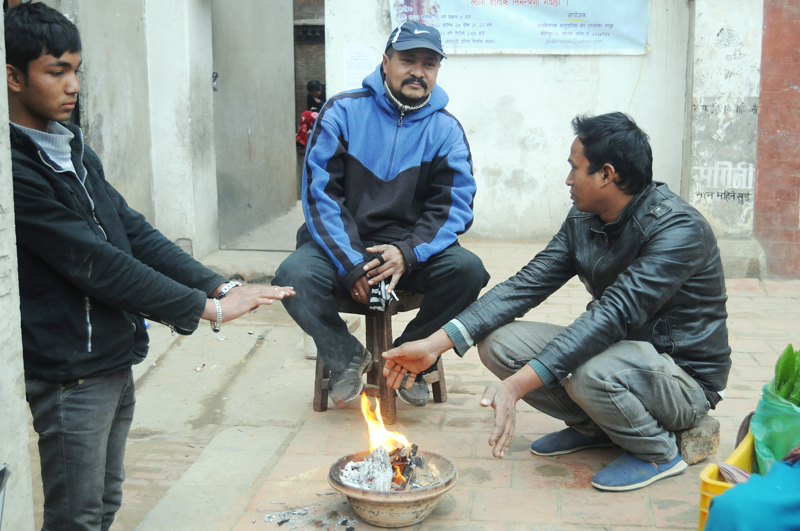 Locals sitting around a fire to beat the cold, in Lalitpur, on Monday, January 2, 2016. Photo: THT