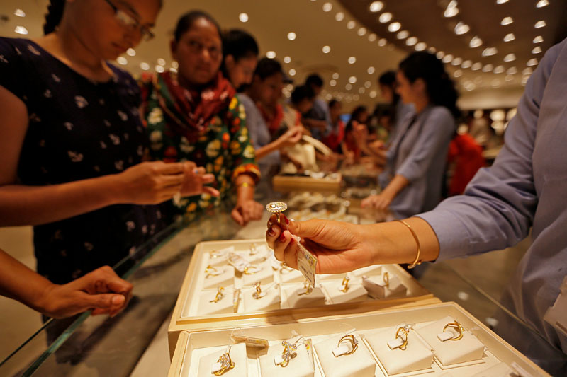 File - A sales person shows a gold ring to customers at a jewellery showroom during Dhanteras, a Hindu festival associated with Lakshmi, the goddess of wealth, in Ahmedabad, India, on October 28, 2016. Photo: Reuters