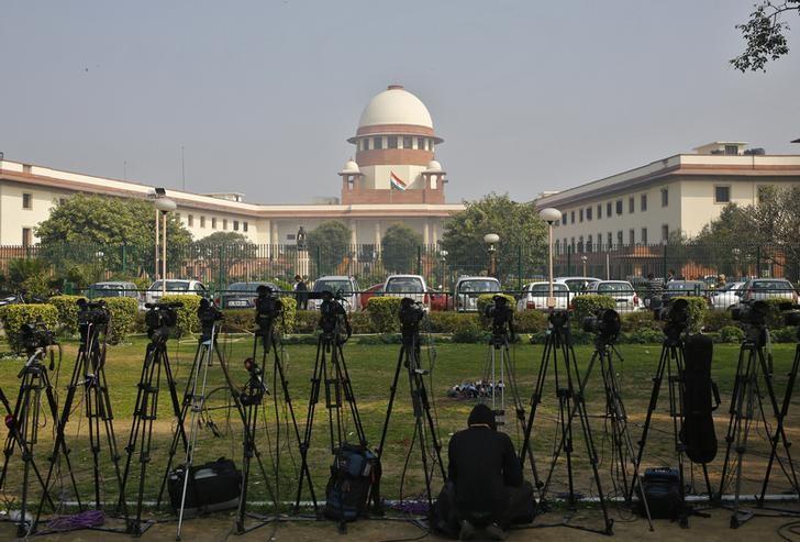 A television journalist sets his camera inside the premises of the Supreme Court in New Delhi February 18, 2014. REUTERS/Anindito Mukherjee/Files