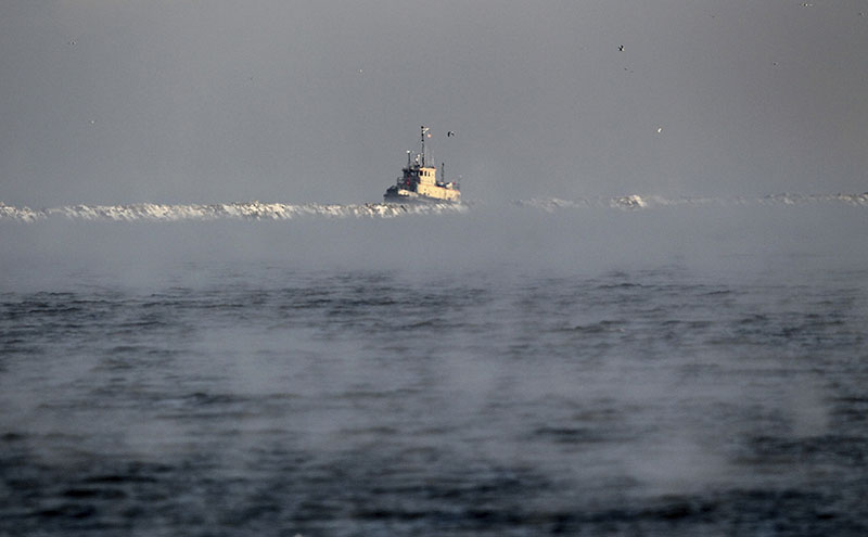 A search vessel travels amidst the morning fog near a break wall at Lake Erie to help in the recovery operation of a missing plane, on Friday, January 6, 2017 near Cleveland. Photo: Marvin Fong/The Plain Dealer via AP