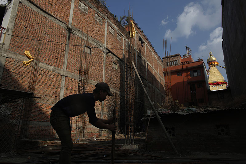 A labourer works at a construction site near the Bouddhanath Stupa.