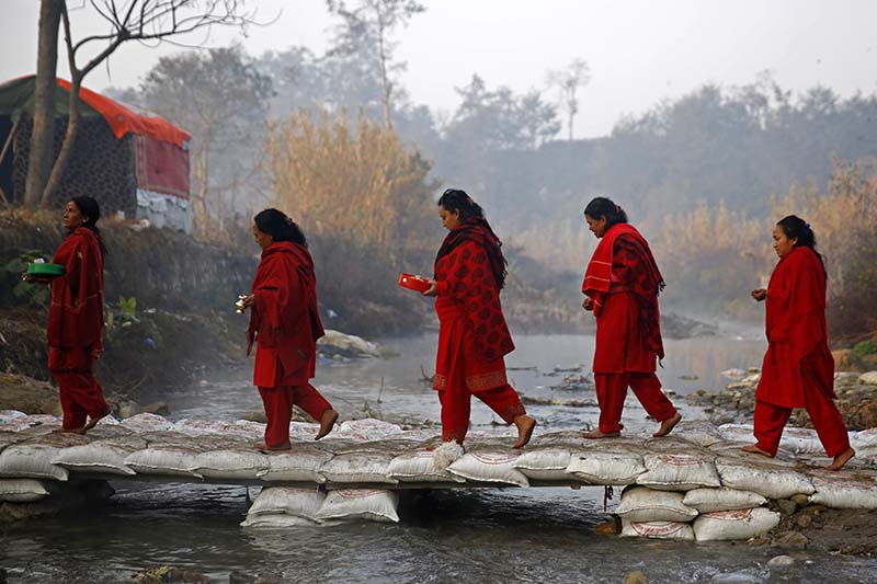 Nepali Hindu women return after taking a holy dip and offering prayers at the Shalinadi River at Sankhu in Kathmandu, on Thursday, January 12, 2017. Photo: Skanda Gautam/THT