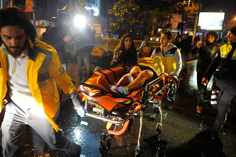 An injured woman is carried to an ambulance from a nightclub where a gun attack took place during a New Year party in Istanbul, Turkey, on January 1, 2017. Photo: Ihlas News Agency via Reuters