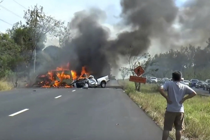 In this image made from video a man watches as two vehicles burn after they collided on a highway east of Bangkok, Thailand, Monday, Jan. 2, 2017. Photo: AP