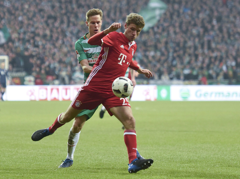Munich's Thomas Mueller in action with Bremen's Niklas Moisander. Photo: AP
