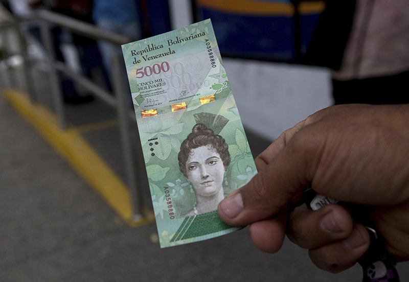 A man shows a new bank note of 5,000 Bolivars outside a bank in Caracas, Venezuela, on Monday, January 16, 2017.  Photo: AP
