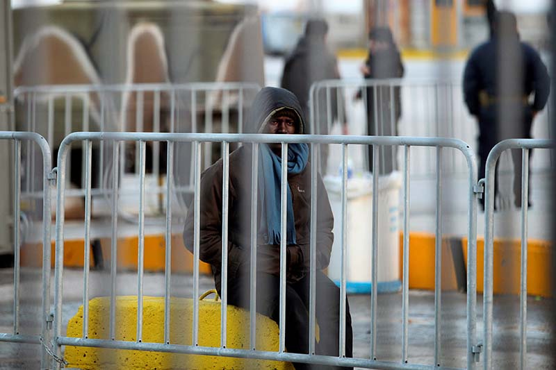 A migrant, who is accommodated at a Greek naval ship used as a shelter for refugees and migrants from bad weather conditions, sits at the port of the Greek island of Lesbos, on January 13, 2017. Photo: Reuters