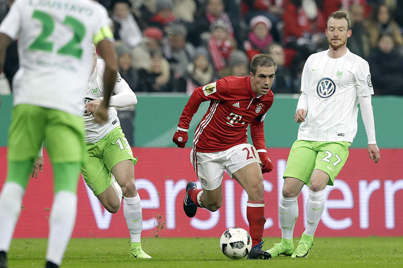 Bayern's Philipp Lahm (centre) controls the ball besides Wolfsburg's Yannick Gerhardt (left, and Wolfsburg's Maximilian Arnold during the German Soccer Cup match between FC Bayern Munich and VfL Wolfsburg at the Allianz Arena stadium in Munich, Germany, on Tuesday, February 7, 2017. Photo: AP