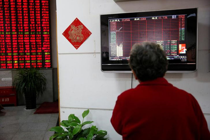 An investor looks at an electronic board showing stock information on the first trading day after the New Year holiday at a brokerage house in Shanghai, China, on January 3, 2017. Photo: Reuters