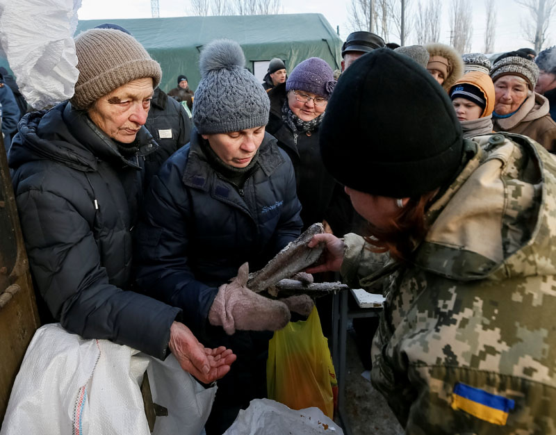 A local resident receives free food (frozen fish) at an emergency center after shelling hit supply infrastructure in the government-held industrial town of Avdiyivka, Ukraine, on February 1, 2017.  Photo: Reuters