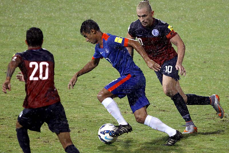 File-Guam's captain Jason Cunliffe (right) and teammate Adolf DeLaGarza (left) chase India's Eugenson Lyngdoh as it rains during their 2018 FIFA World Cup qualifying match in Bangalore, India on November 12, 2015. Photo: AP