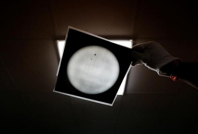 A technician holds the photographic film plate with observational data inside the archival digitisation lab at the Kodaikanal Solar Observatory,  February 3, 2017. REUTERS/Danish Siddiqui