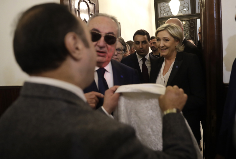 An aide of Lebanon's Grand Mufti Sheikh Abdel-Latif Derian, left, gives a head scarf to French far-right presidential candidate Marine Le Pen, right, to wear during her meeting with the Mufti but she refused, upon her arrival at Dar al-Fatwa the headquarters of the Sunni Mufti, in Beirut, Lebanon, Tuesday, Feb. 21, 2017. Photo: AP