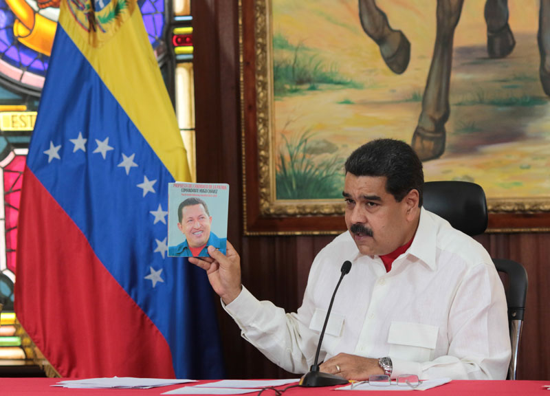 Venezuela's President Nicolas Maduro holds an image of Venezuela's late President Hugo Chavez as he speaks during a meeting with governors in Caracas, Venezuela on February 14, 2017. Photo: Miraflores Palace via Reuters