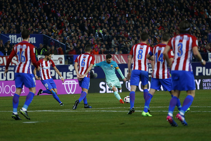 Barcelona's Lionel Messi (centre) shoots the ball to scored past Atletico Madrid defenders his side's second goal during a Spanish Copa del Rey semi-final first leg soccer match between Atletico Madrid and Barcelona at the Vicente Calderon stadium in Madrid, on Wednesday, February 1, 2017. Photo: AP