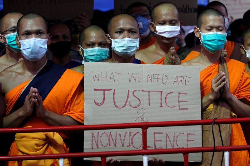 Monks hold a placard inside Dhammakaya Buddhist temple while defying orders to leave its grounds to enable police to seek out their former abbot in Pathum Thani, Thailand February 19, 2017. Photo: Reuters